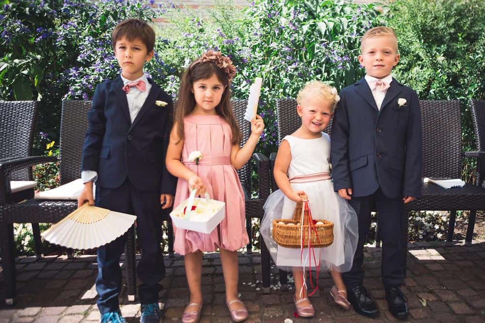 Children in a patio dressed up for a wedding.