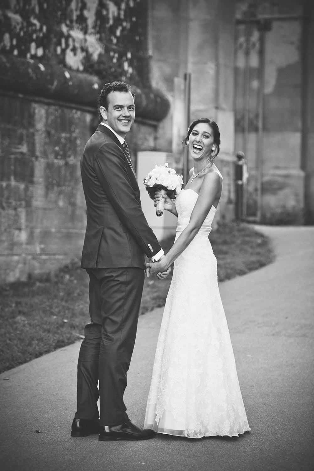 Black and white photo of a couple smiling on their wedding day.