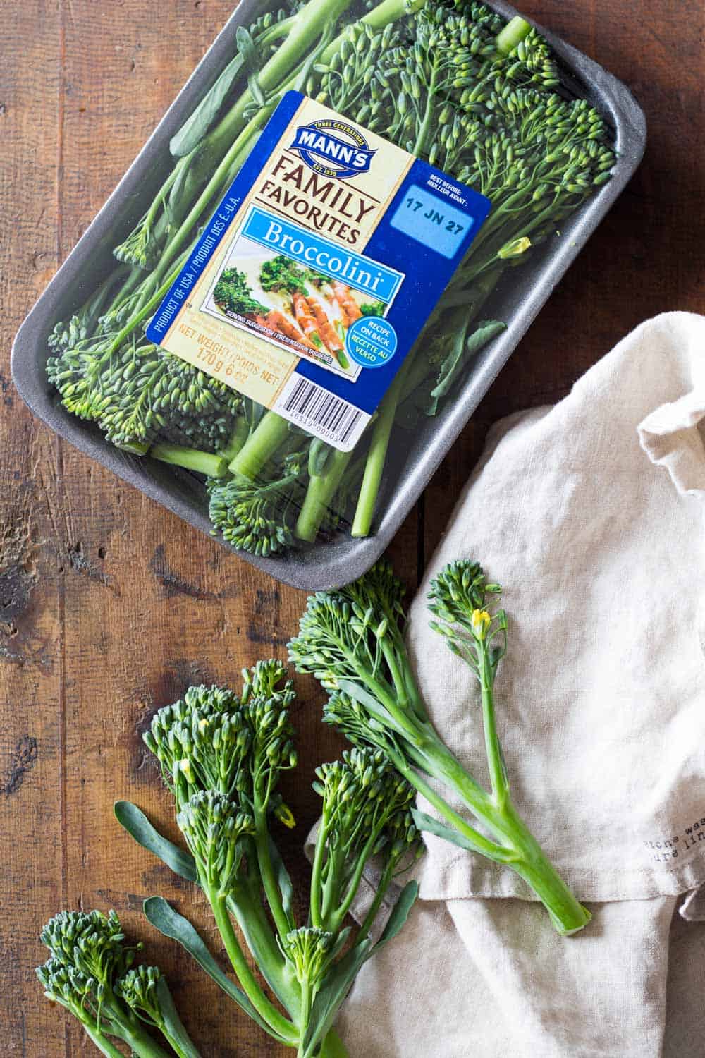 Mann's broccolini package and loose broccolini branches presented outside the package on a table