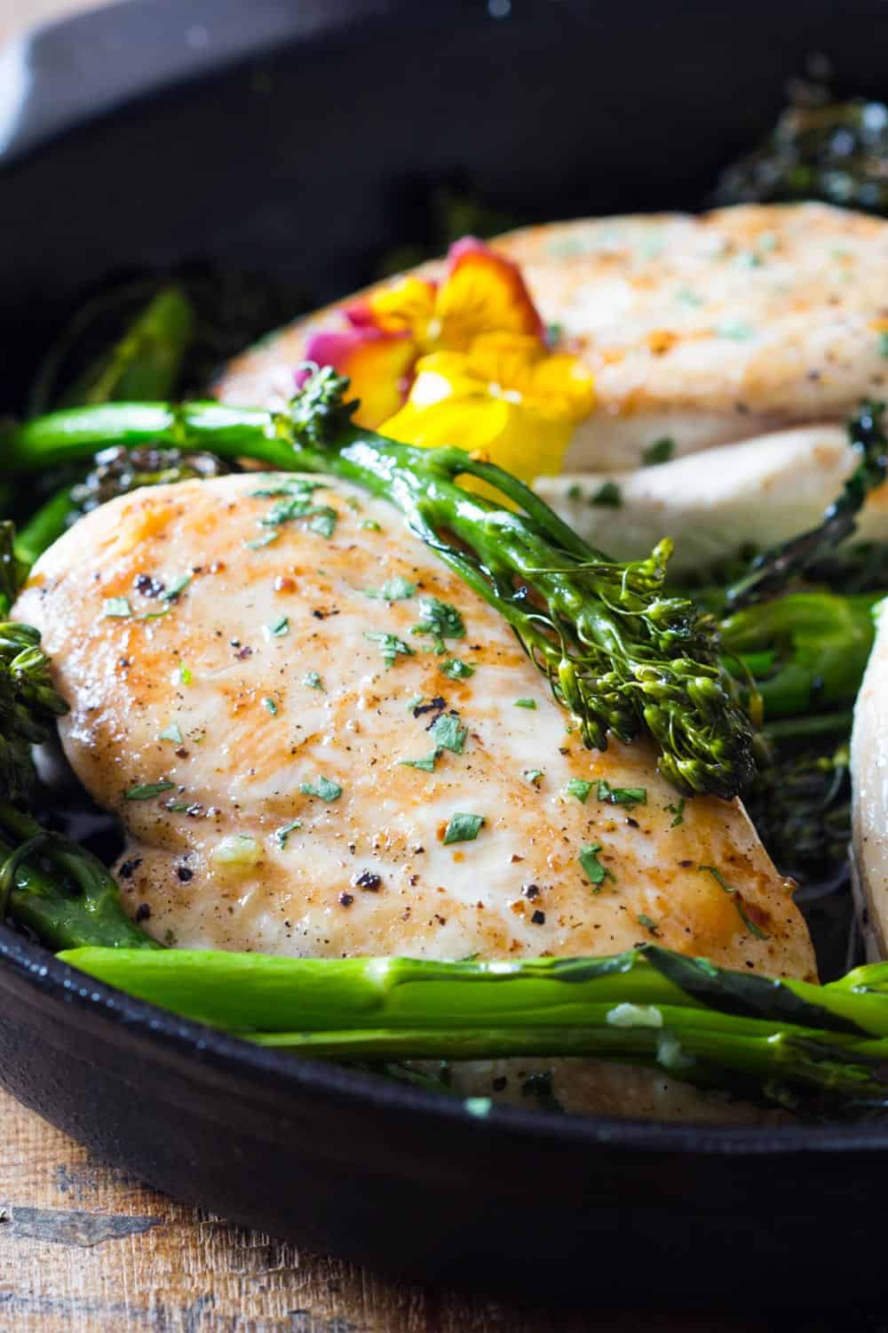 Cooked chicken breast with broccolini on a plate