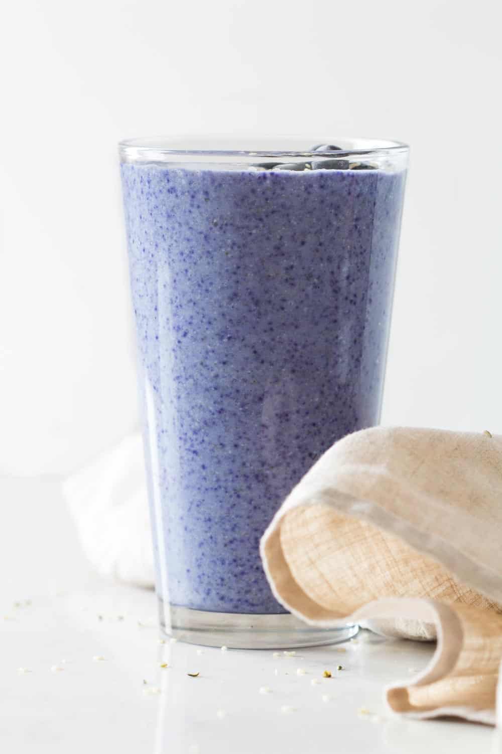 Blue Smoothie in a tall glass filled to the rim.
