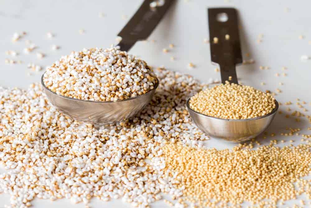 A measuring spoon with popped amaranth and a measuring spoon with raw amaranth.