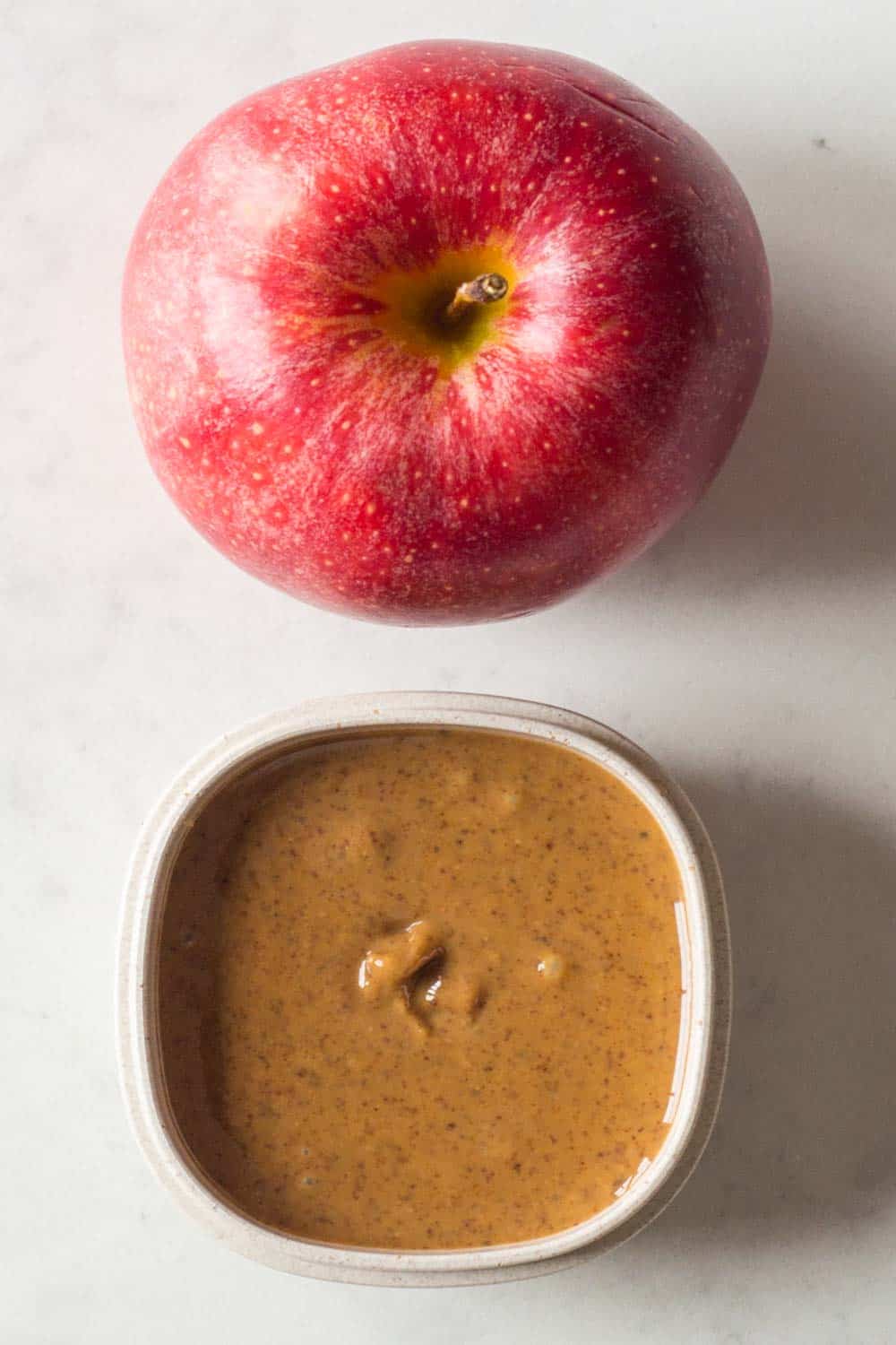 A healthy Paleo Snack for your Paleo Meal Plan - apple slices dipped in almond butter.