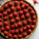 Chocolate Raspberry Tart with grey napkin next to it.