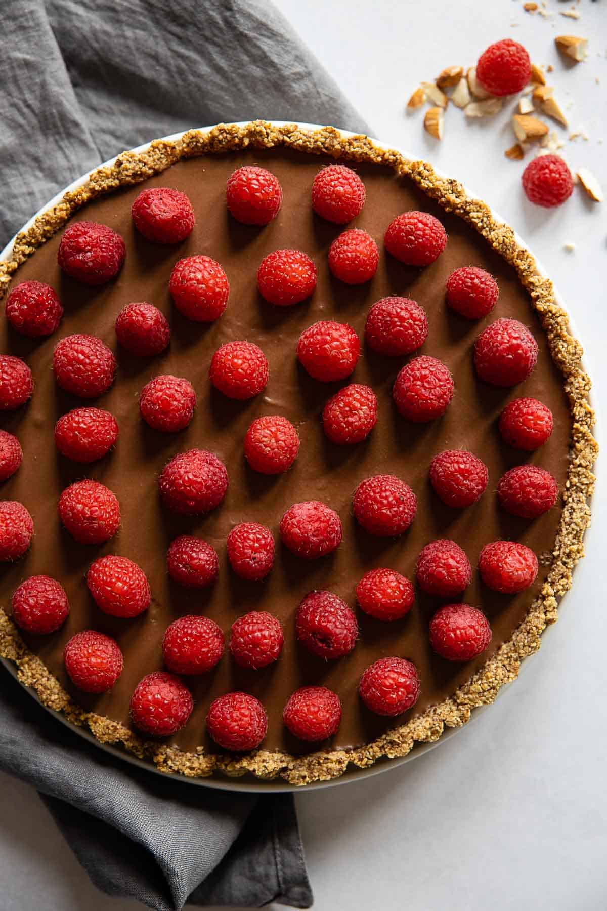 Chocolate Raspberry Tart with grey napkin next to it.