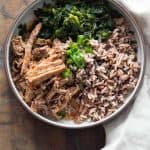 A plate with Slow-Cooker Pot Roast, brown rice, puy lentils, and sautéed spinach.