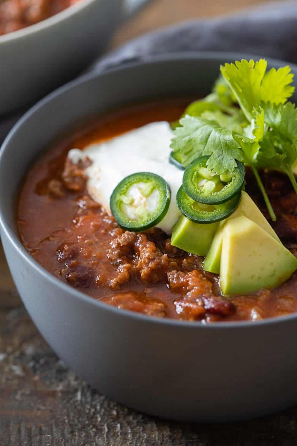 Closeup of texture of chili con carne in a grey bowl.