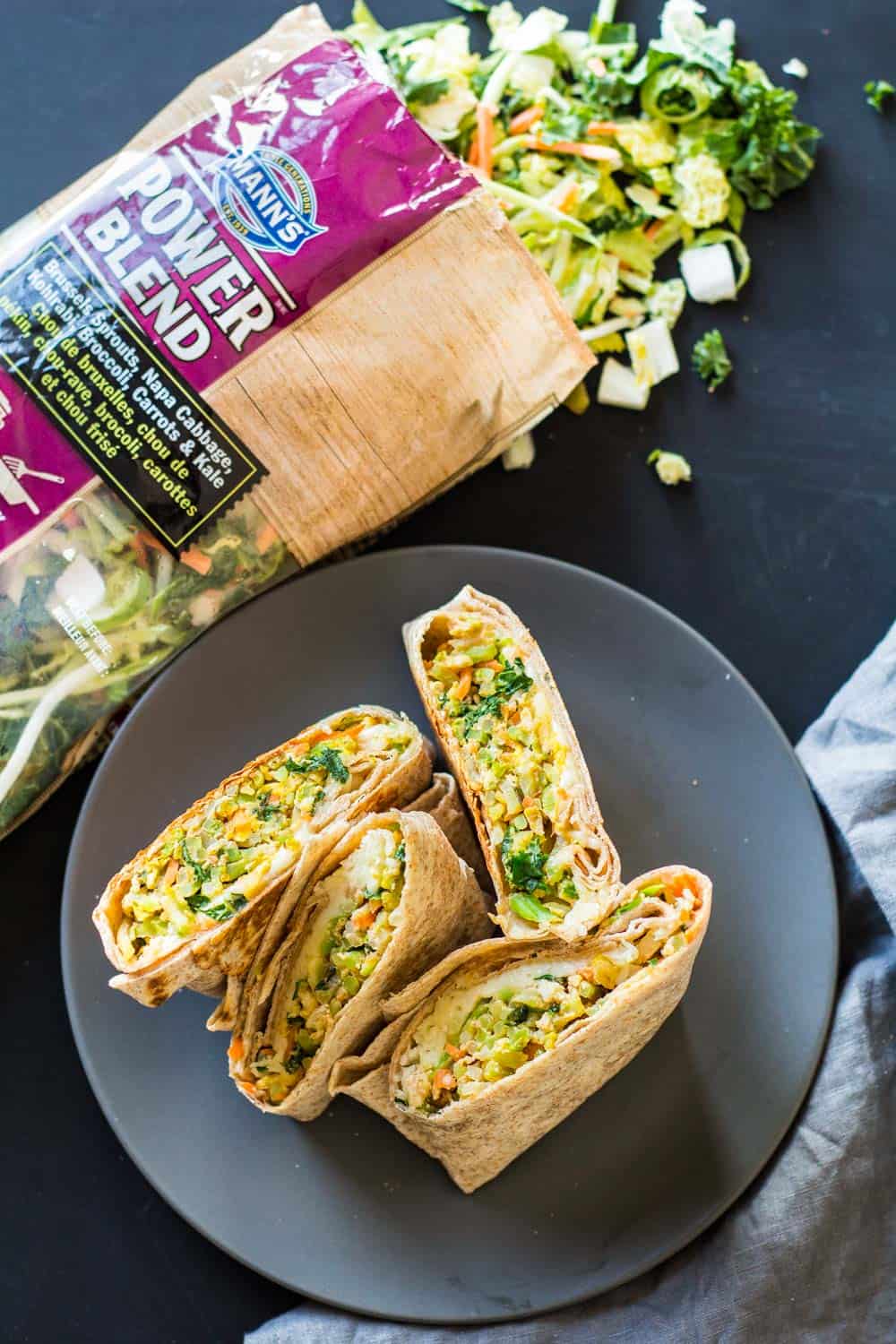 breakfast burrito on a plate with bag of vegetables