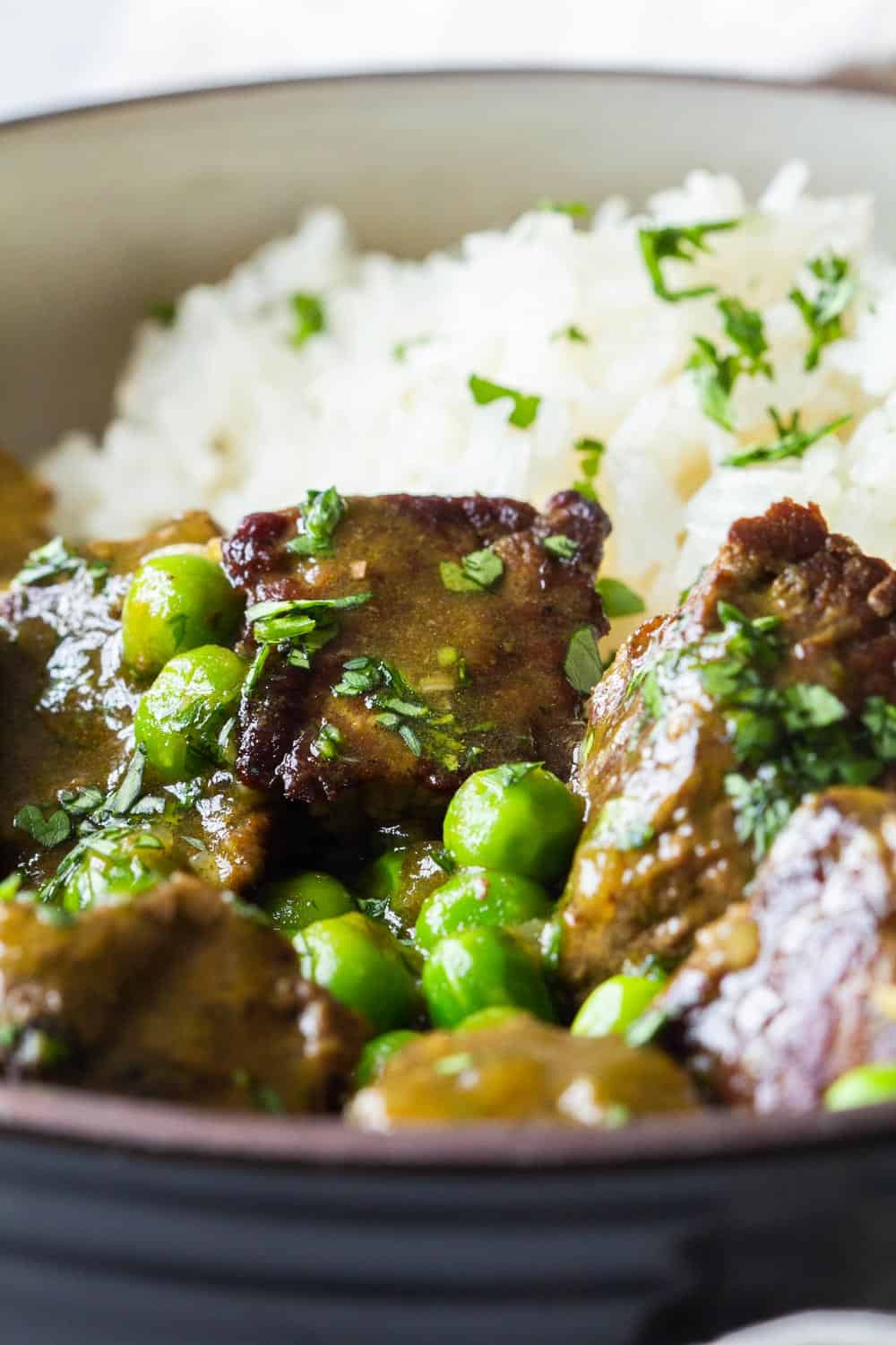 Close-up of texture of Instant Pot Beef Stew with peas and white rice