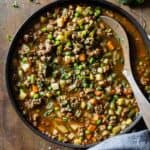 Mexican Picadillo in a large pan on a wooden table.