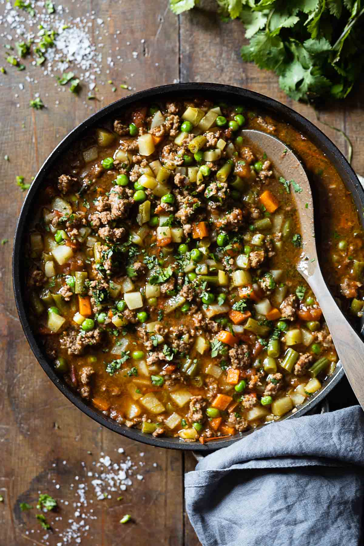 Mexican Picadillo in a large pan on a wooden table.