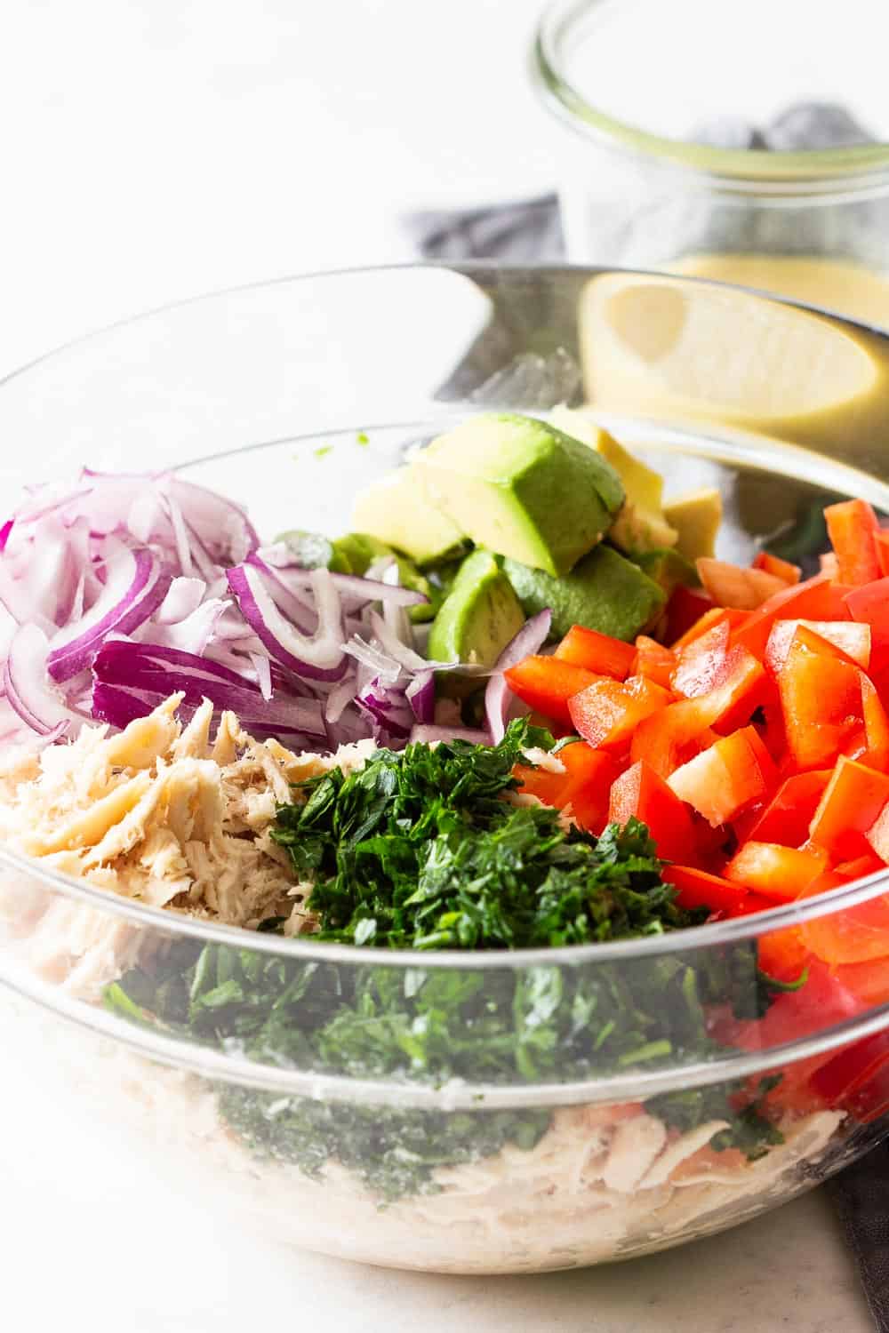 Tuna and Avocado Salad deconstructed in a glass bowl with dressing on the side