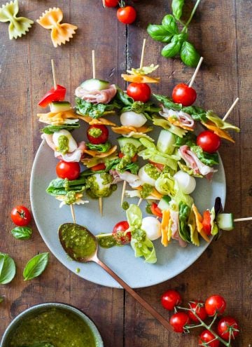 Antipasto Skewers drizzeled with green pesto on a plate