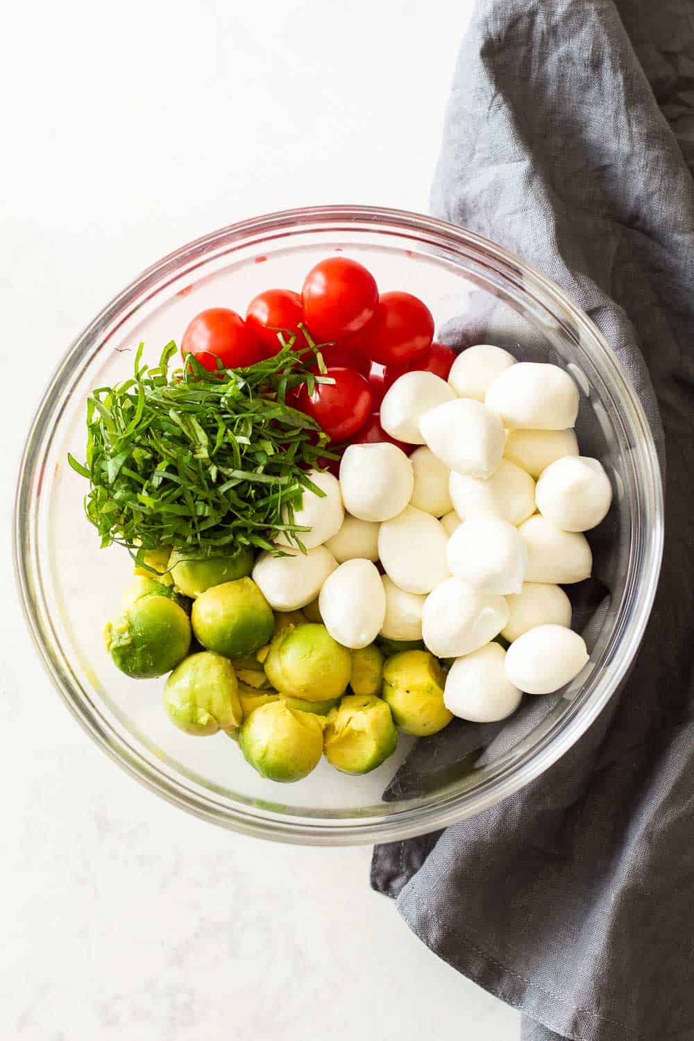 Ingredients for Avocado Tomato Salad in a glass bowl