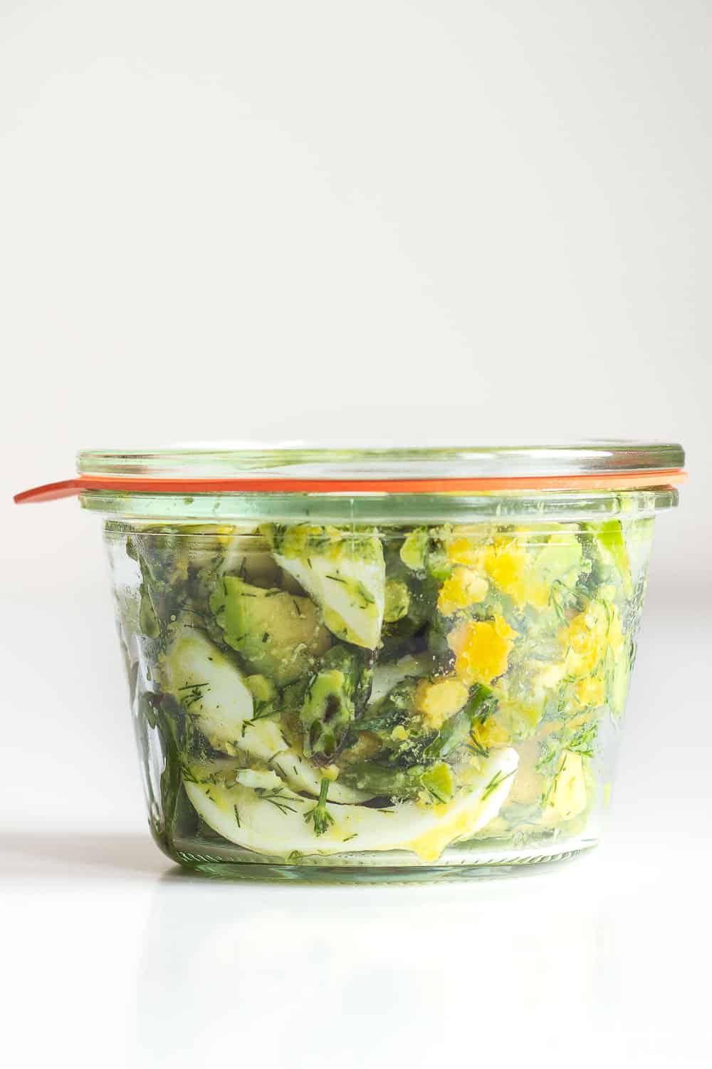 Avocado Egg Salad in a meal prep glass container with lid on.