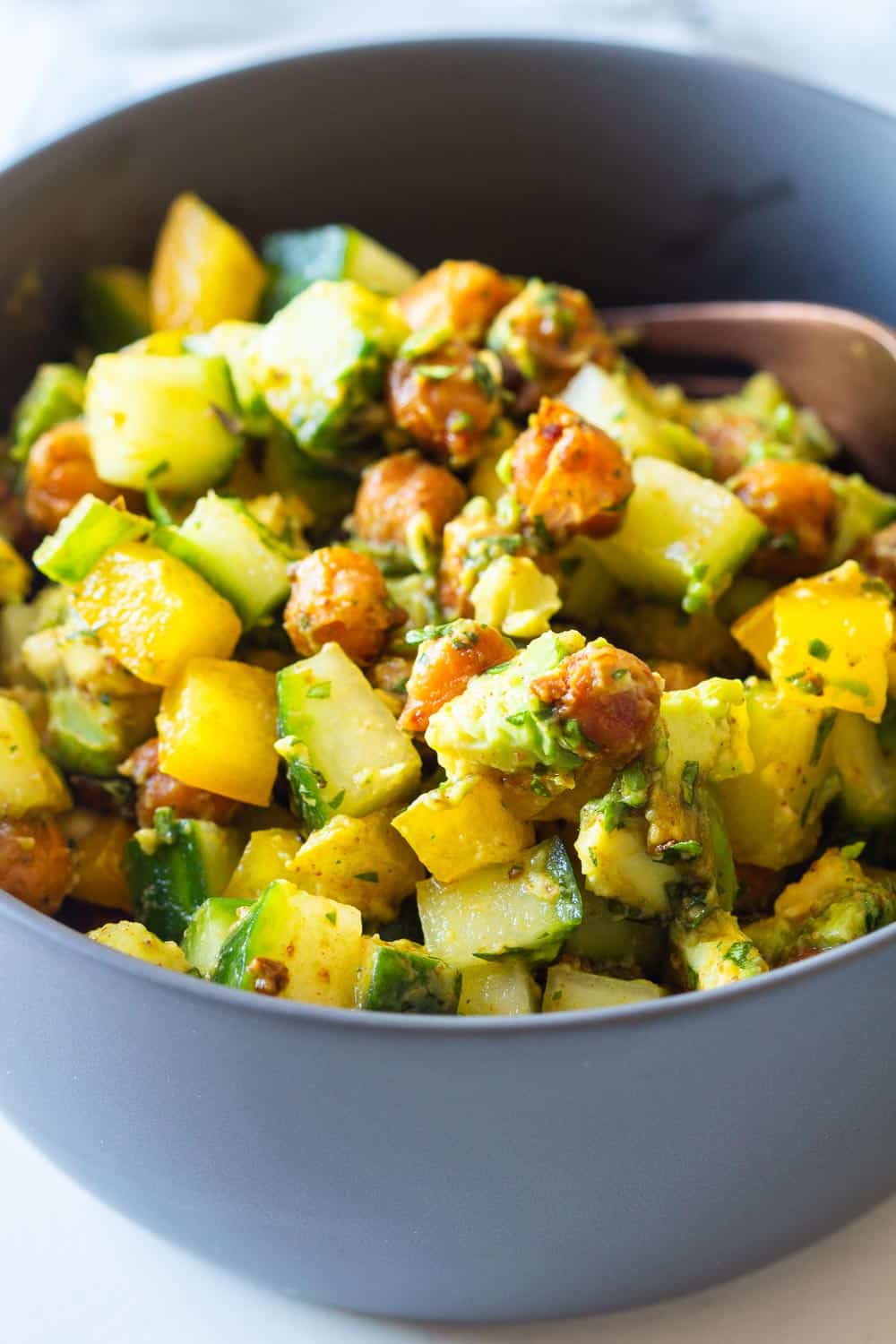 Mixed up Cucumber Avocado Salad in a small grey bowl