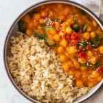 Sweet Potato Curry with chickpeas and baby spinach made in Instant Pot served with brown rice in a round bowl.