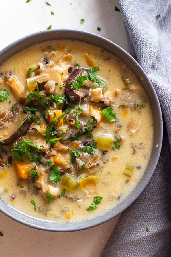 Chicken Wild Rice Soup in a grey bowl topped with chopped parsley.