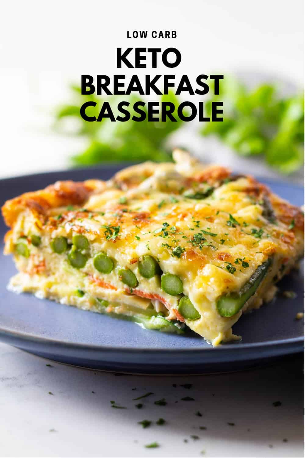 Piece of low carb breakfast casserole with asparagus and melted cheese on a blue plate