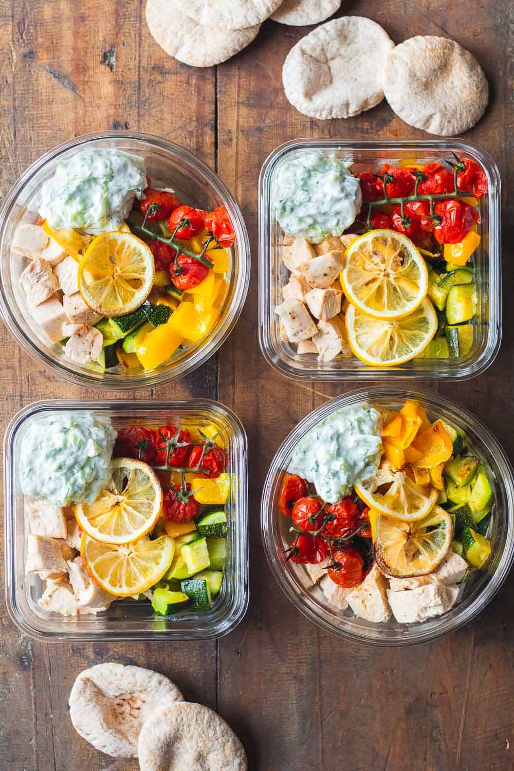 4 Greek Chicken Meal Prep Bowls with Tzatziki and pita bread