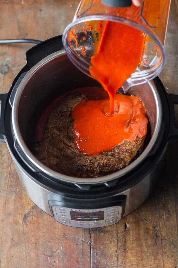 Pouring Roasted Red Bell Pepper Sauce on to Instant Pot Pot Roast