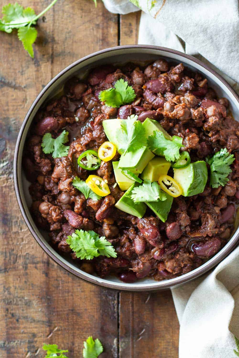 Instant Pot Vegan Chili topped with fresh avocado, cilantro and chili slices