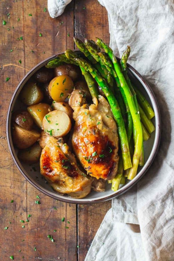 Crockpot Lemon Chicken with potatoes and asparagus in a bowl.