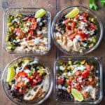 Four Mexican Chicken Meal Prep Containers on a wooden table.