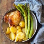 Instant Pot Lemon Chicken on a plate with potatoes and asparagus