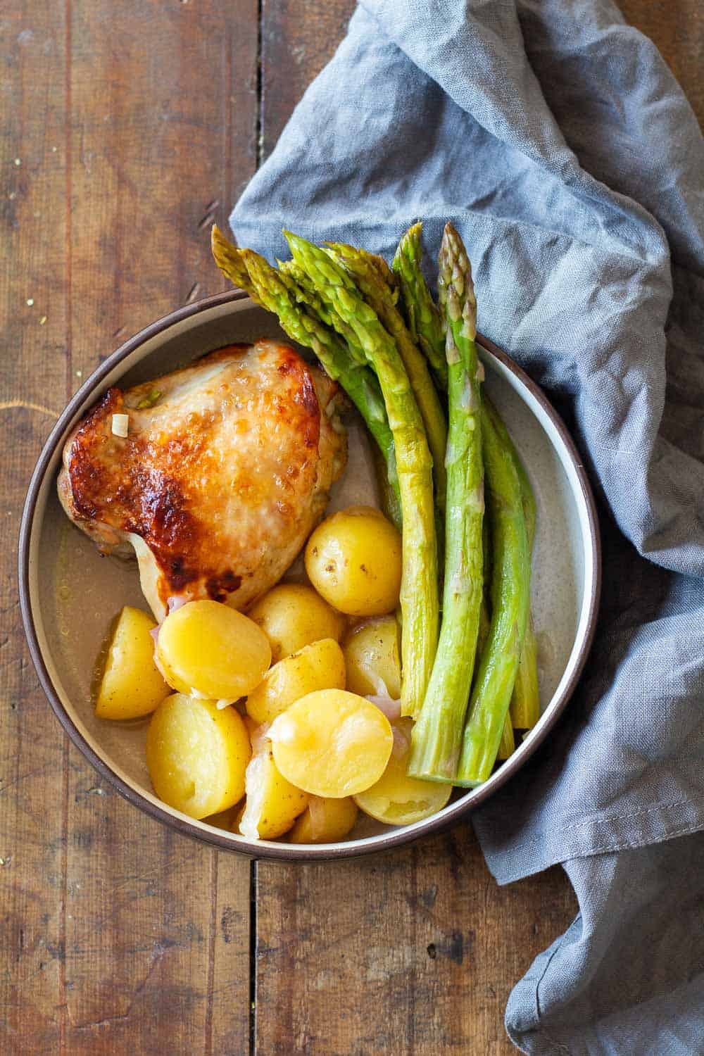 Instant Pot Lemon Chicken on a plate with potatoes and asparagus