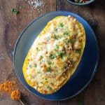 top down view of stuffed spaghetti squash on a blue plate on a wooden table