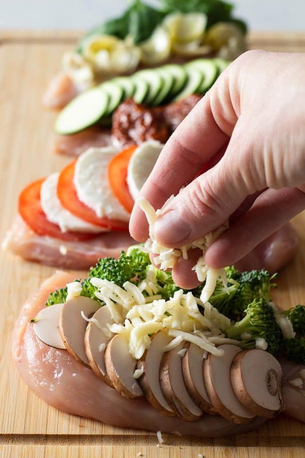 placing fillings on a chicken breast to create Broccoli Cheese Stuffed Chicken Breasts