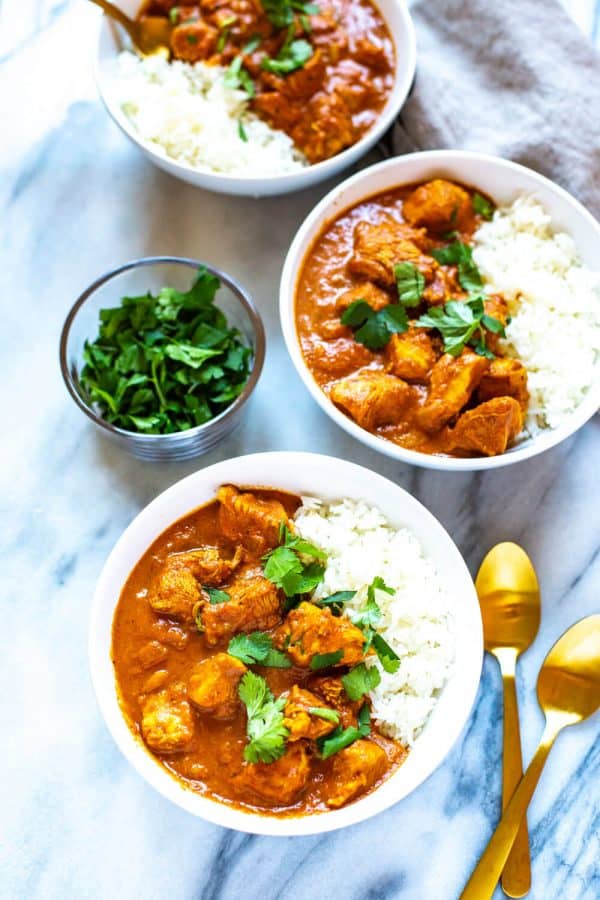 bowls of chicken tikka masala served over white rice