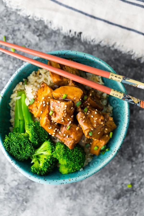 teriyaki chicken in a blue bowl with chopsticks