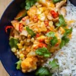 Thai Chicken Cauliflower Curry next to white rice in a blue serving bowl.