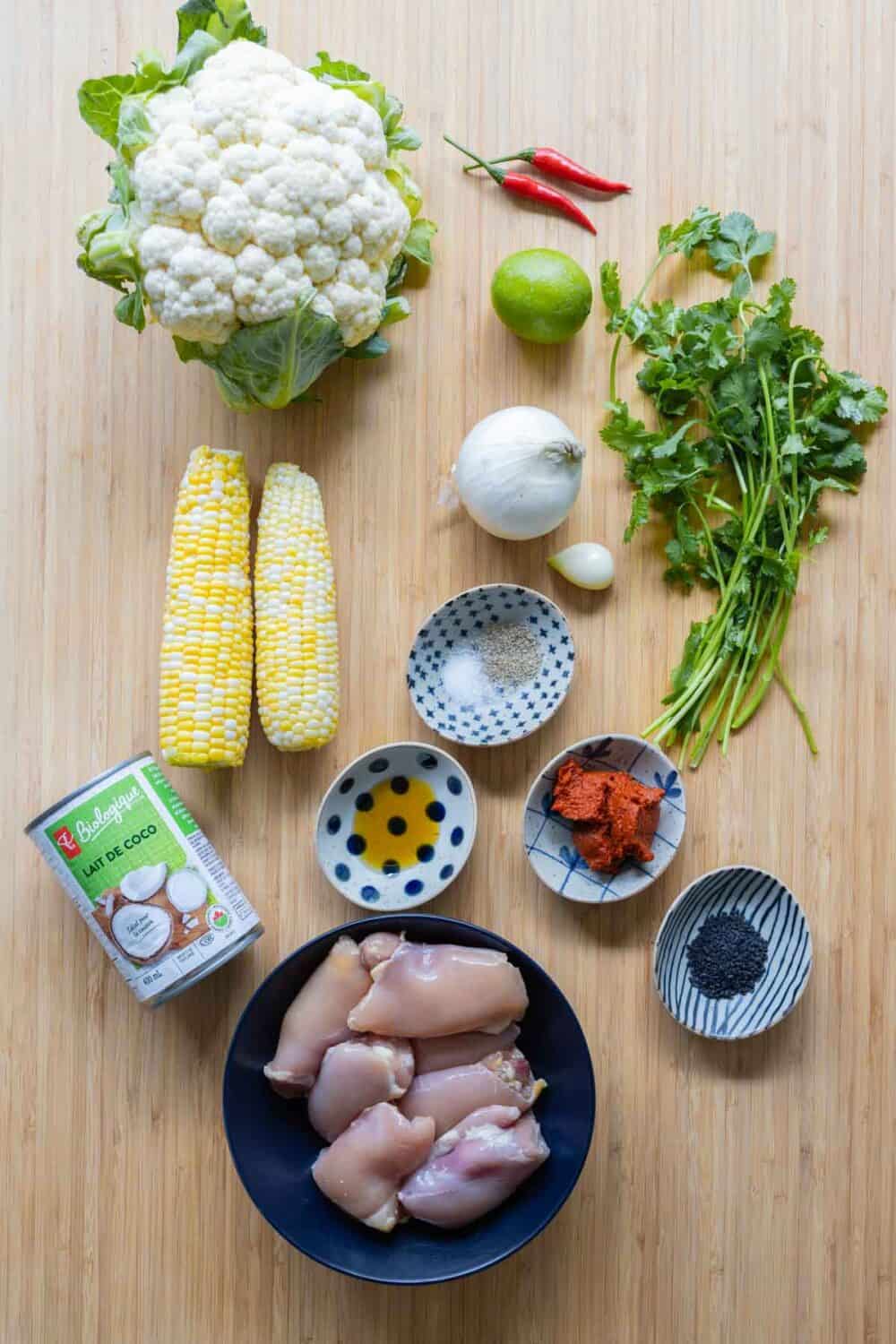 Ingredients for Thai Chicken Cauliflower Curry laid out on a kitchen counter.