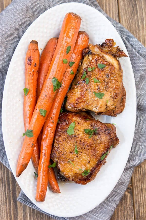 slow cooker balsamic chicken thighs and carrots on white platter