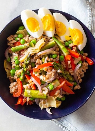 Farro Spring Salad in a bowl with hard boiled eggs on top
