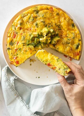 Vegetabel Frittata with 1/4 cup out and one piece in hand to show texture.