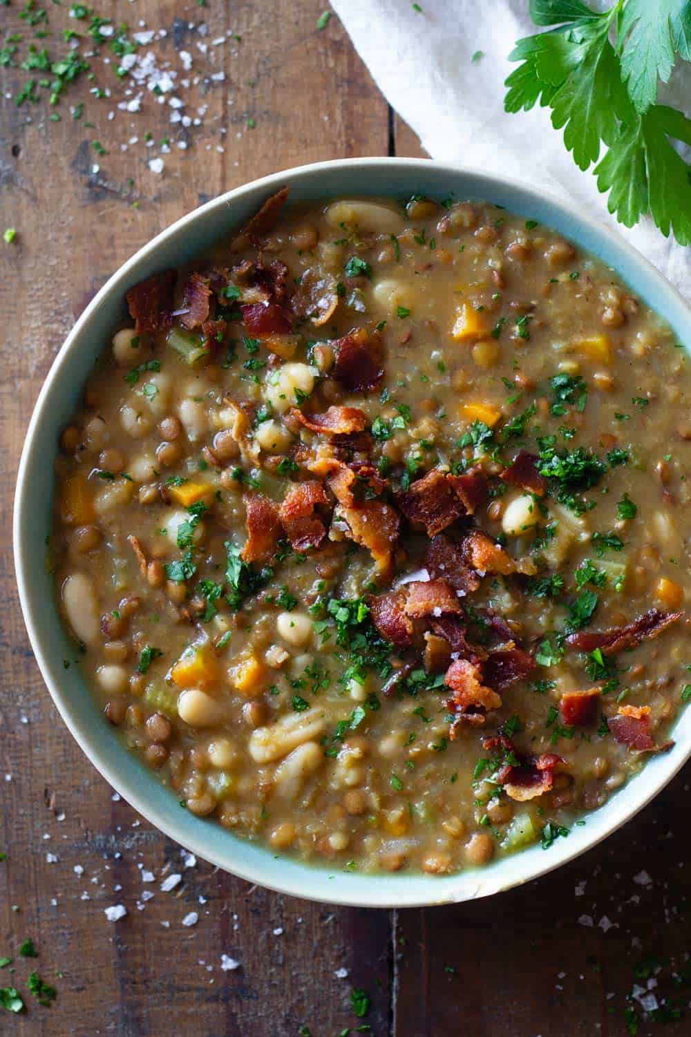 Crockpot Lentil Soup in a blue bowl topped with bacon