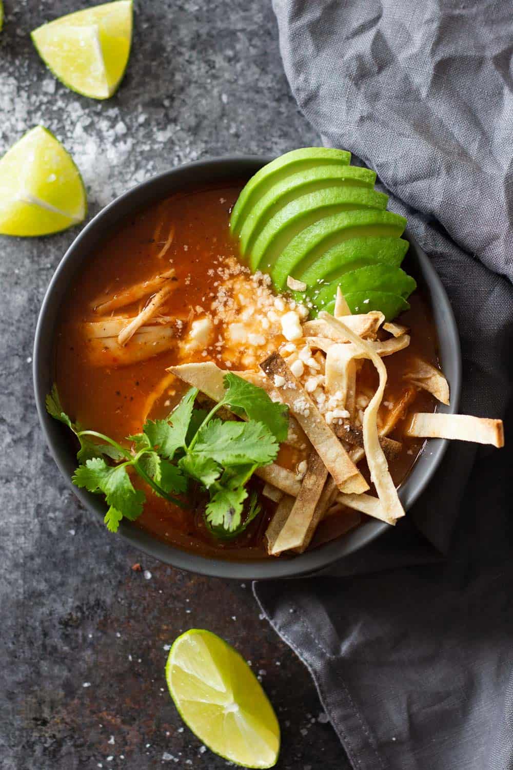 Instant Pot Chicken Tortilla Soup in a black bowl topped with avocado tortilla strips and cilantro