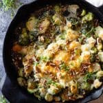 Brussels Sprouts in a black cast iron pan with melted cheese on top