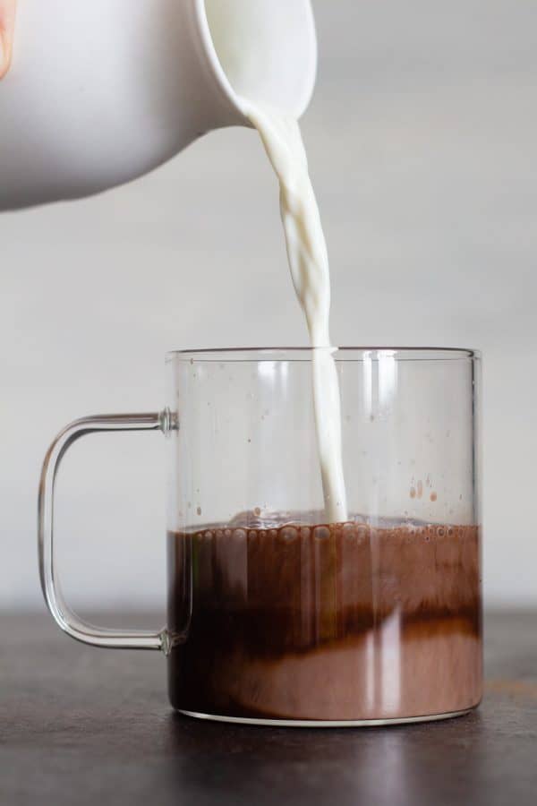 Adding milk to Slow Cooker Hot Chocolate in a cup