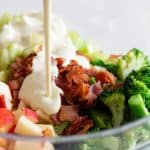 Broccoli Salad in a bowl and dressing poured in