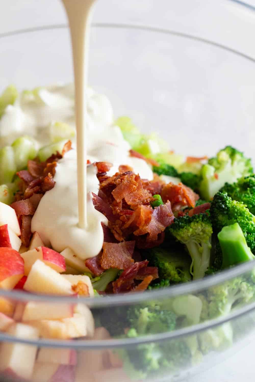 Broccoli Salad in a bowl and dressing poured in