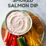 Smoked salmon dip with crackers and raw vegetables arranged on a plate