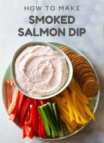 Smoked salmon dip with crackers and raw vegetables arranged on a plate