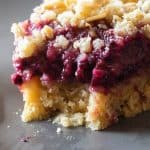 One piece of a Blackberry Pie with crumbles on top.