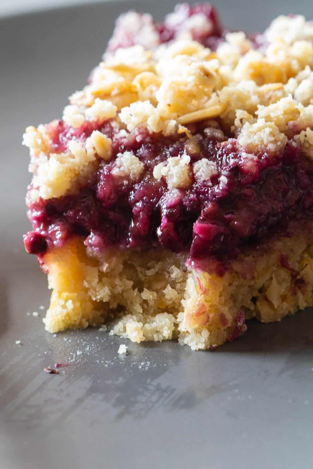 One piece of a Blackberry Pie with crumbles on top.