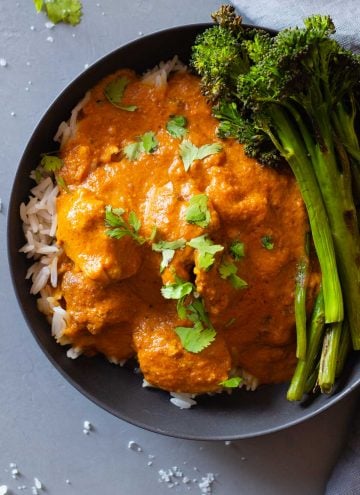 texture of butter chicken in a grey bowl over white rice